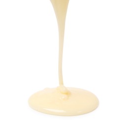 Photo of Pouring delicious condensed milk isolated on white