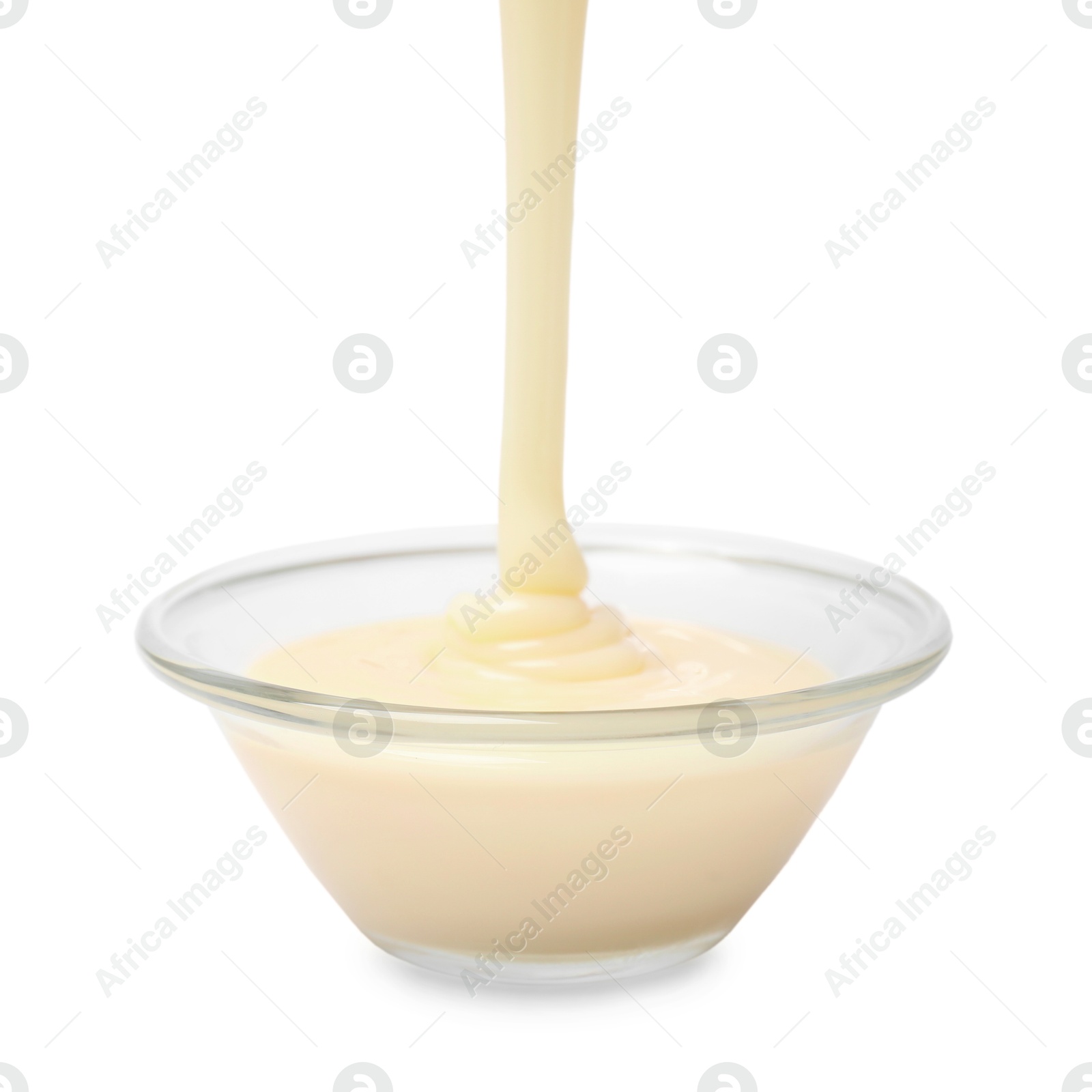 Photo of Pouring condensed milk into bowl isolated on white