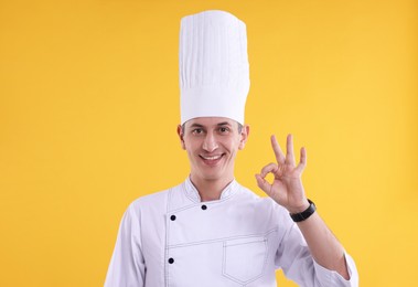 Photo of Professional chef showing okay gesture on orange background