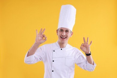 Photo of Professional chef showing okay gesture on orange background