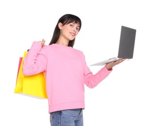 Photo of Internet shopping. Smiling woman with laptop and colorful bags on white background