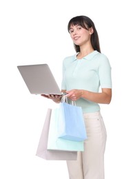 Photo of Internet shopping. Happy woman with laptop and colorful bags on white background