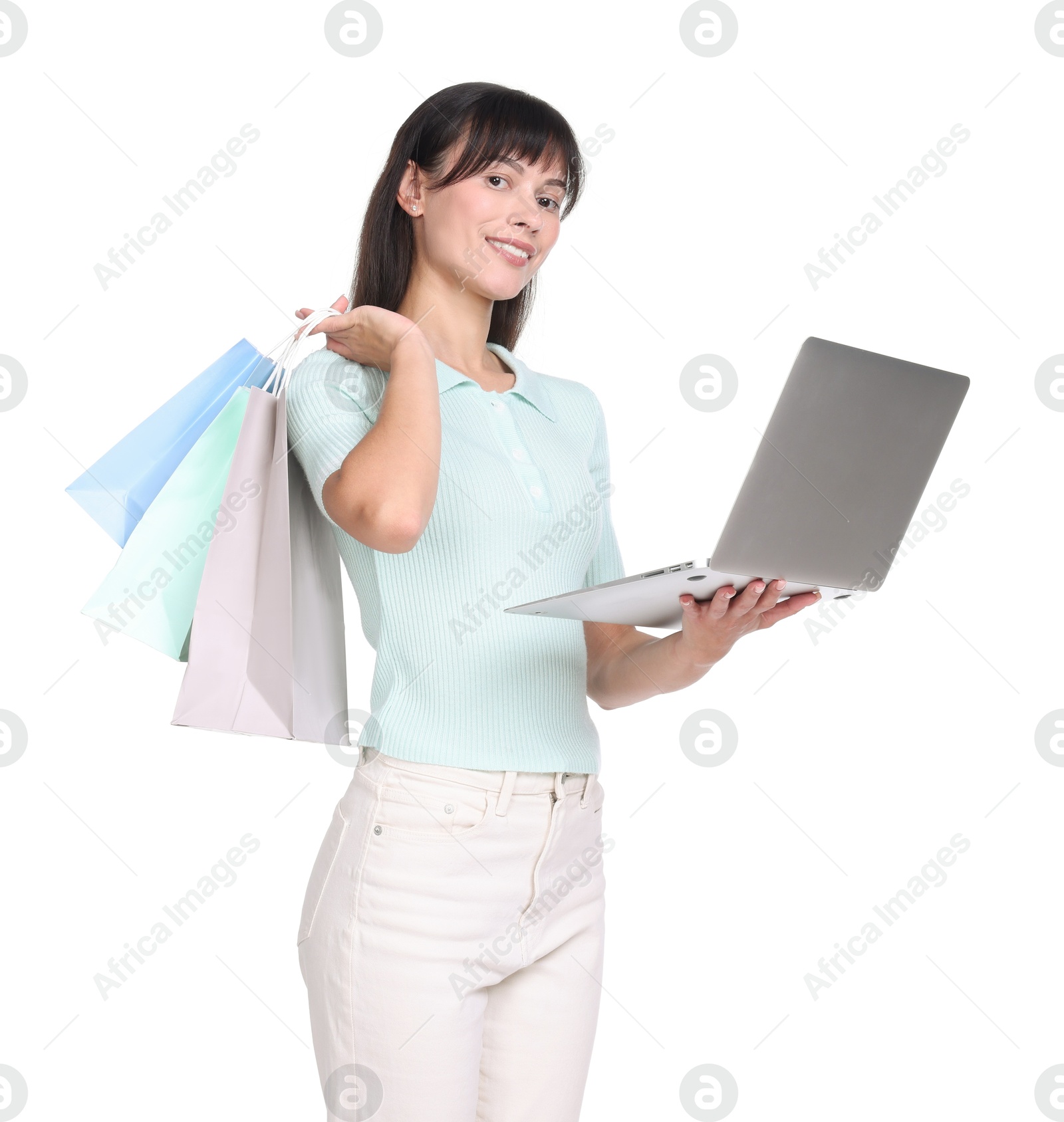 Photo of Internet shopping. Happy woman with laptop and colorful bags on white background