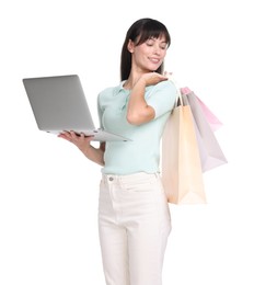 Photo of Internet shopping. Happy woman with laptop and colorful bags on white background