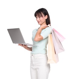 Photo of Internet shopping. Beautiful woman with laptop and colorful bags on white background