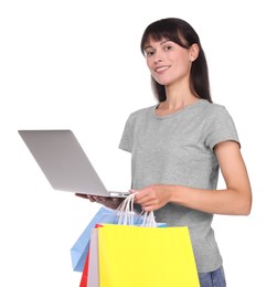 Photo of Internet shopping. Smiling woman with laptop and colorful bags on white background