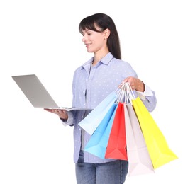 Photo of Internet shopping. Smiling woman with laptop and colorful bags on white background