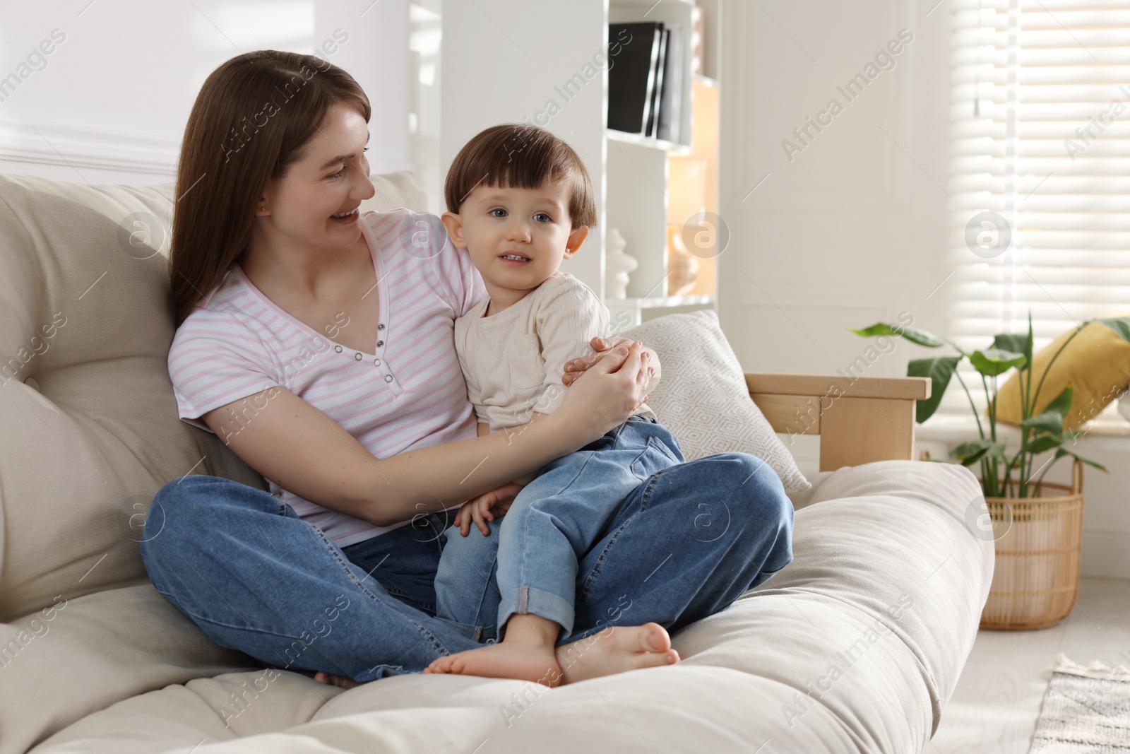 Photo of Happy mother with her cute little son on sofa at home