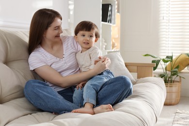 Photo of Happy mother with her cute little son on sofa at home