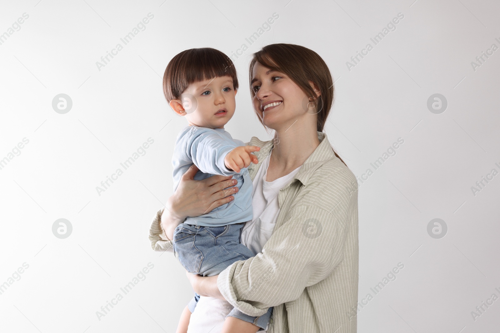 Photo of Beautiful mother with her cute little son on light grey background