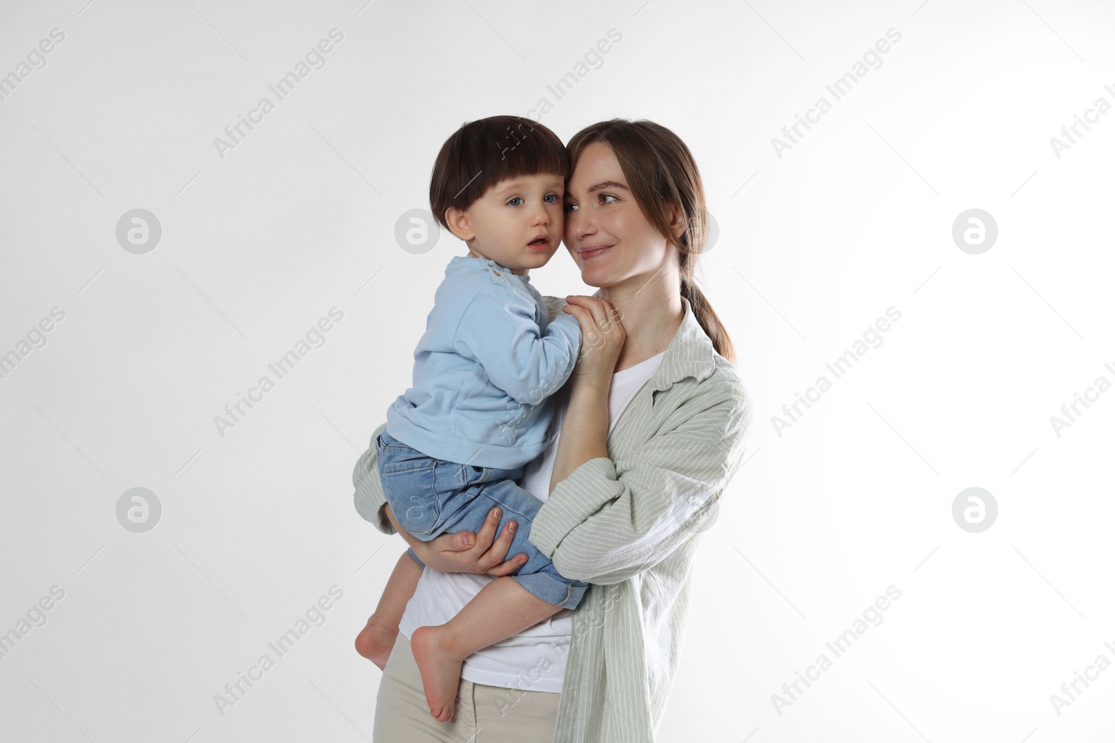 Photo of Beautiful mother with her cute little son on light grey background