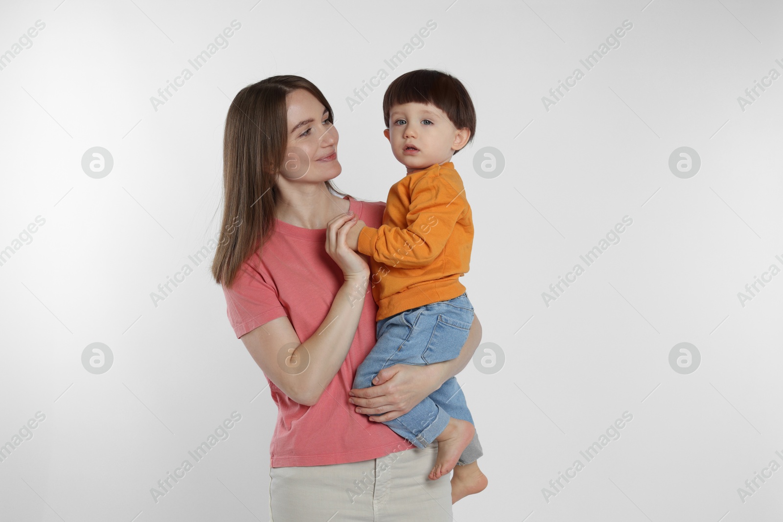 Photo of Beautiful mother with her cute little son on light grey background