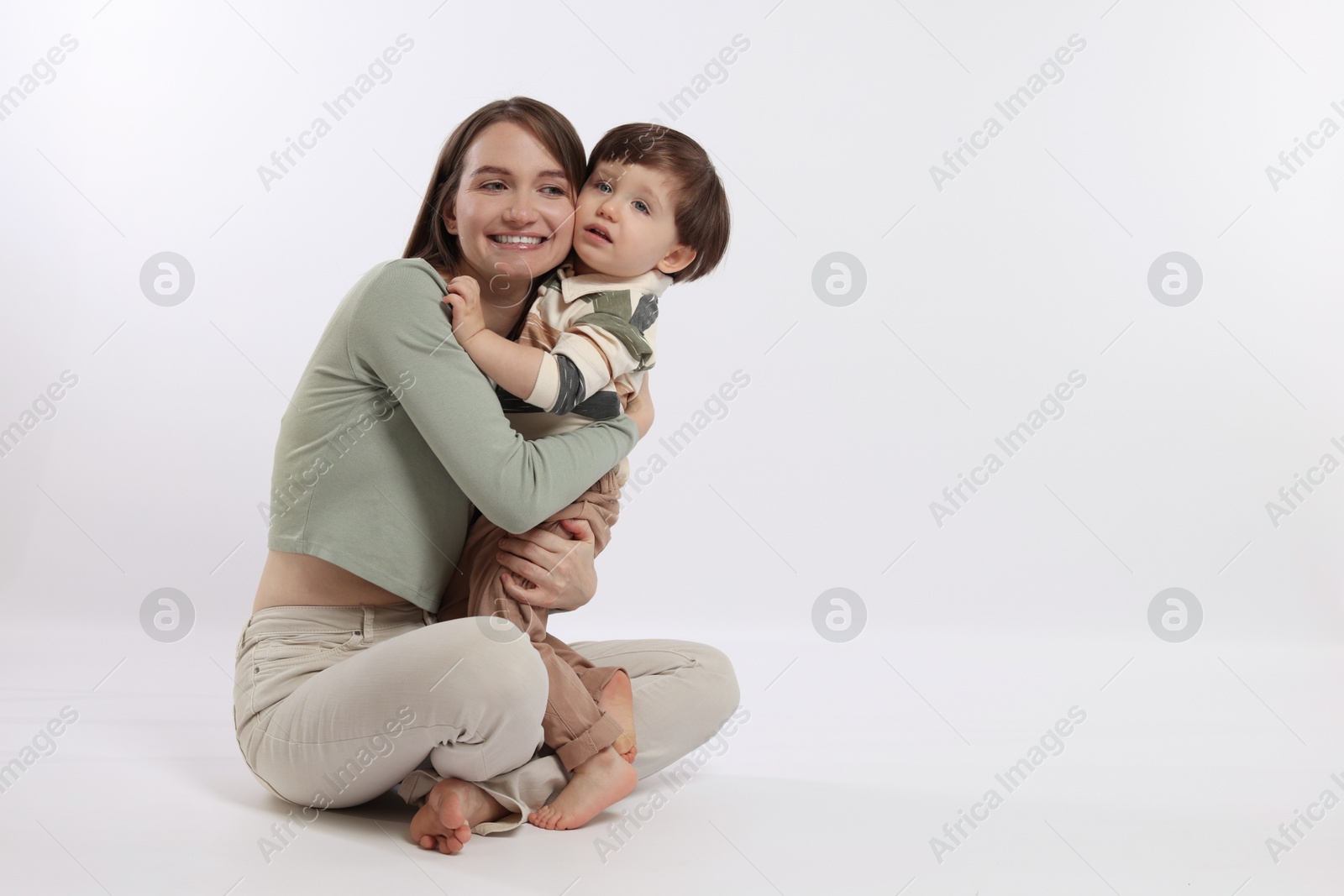 Photo of Happy mother with her cute little son on white background, space for text