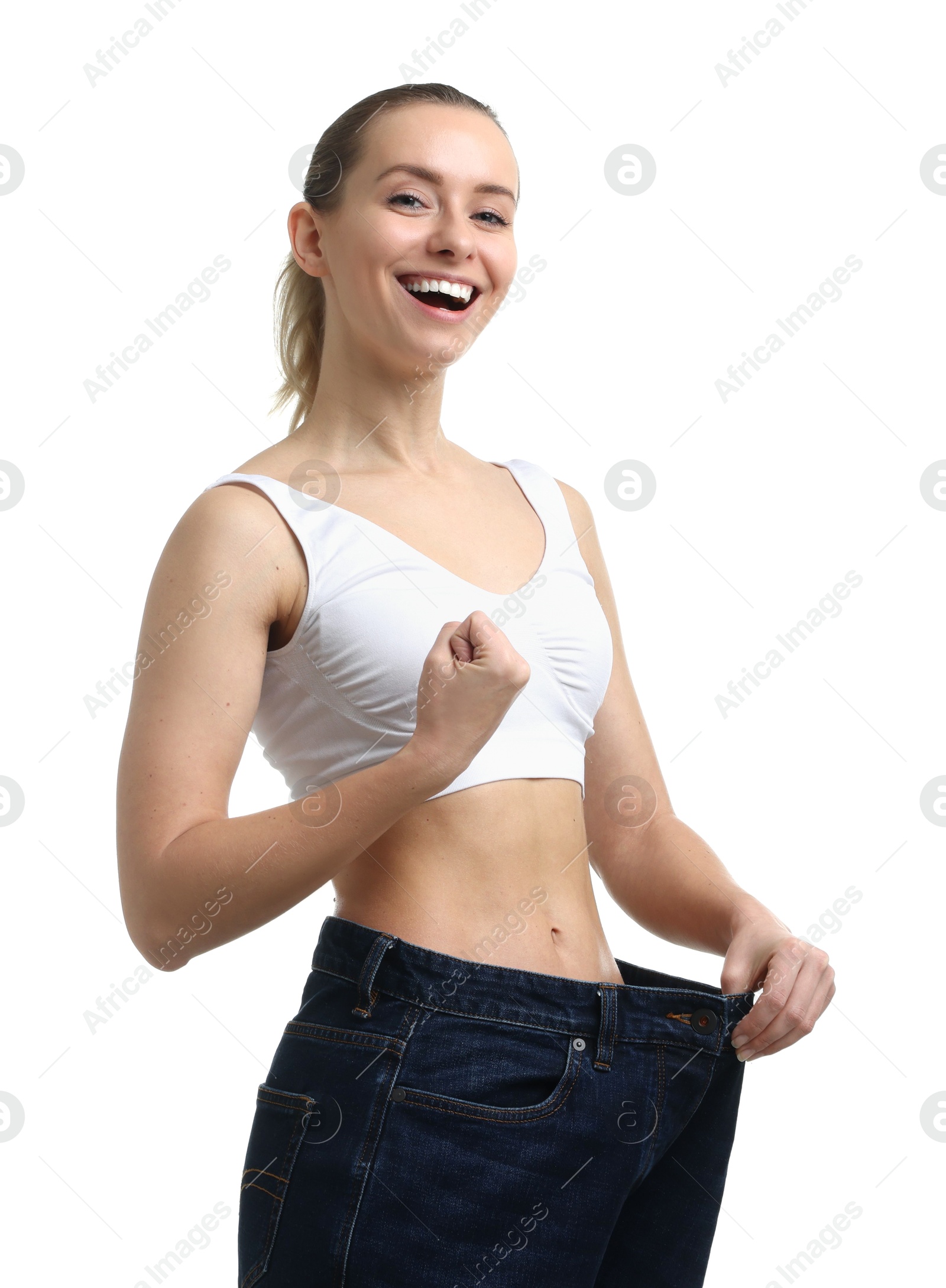 Photo of Weight loss. Happy woman wearing big jeans on white background