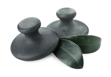 Spa stones and green leaves isolated on white