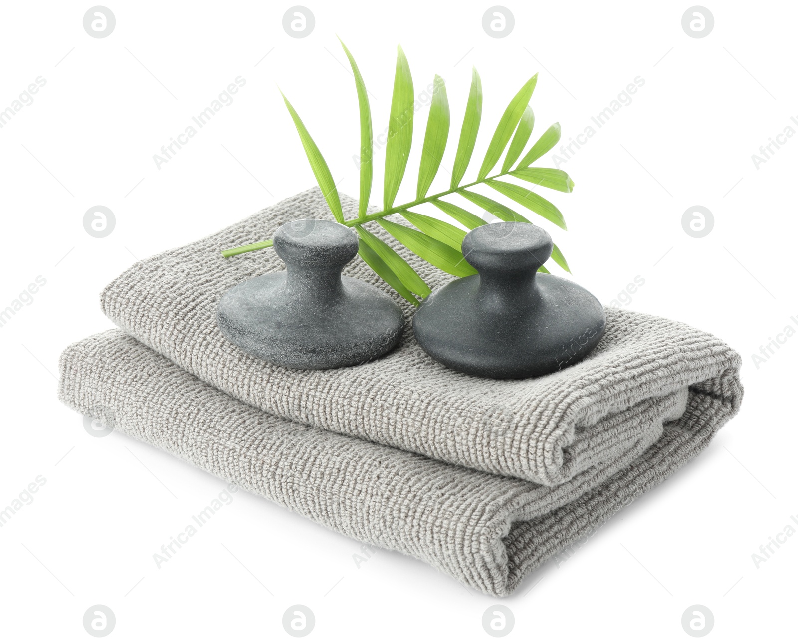 Photo of Spa stones, towel and green palm leaf isolated on white