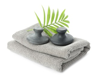 Photo of Spa stones, towel and green palm leaf isolated on white