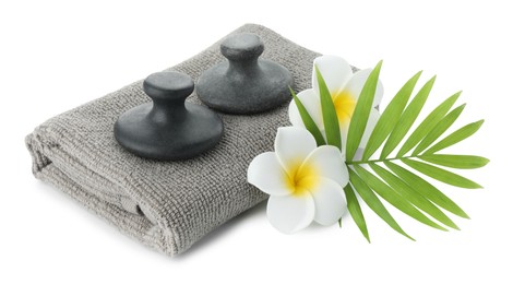 Spa stones, towel, green leaf and plumeria flowers isolated on white