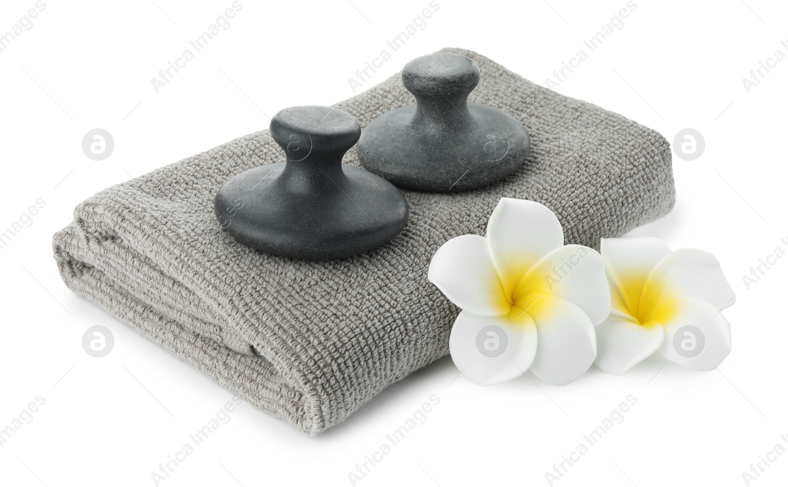 Photo of Spa stones, towel and plumeria flowers isolated on white