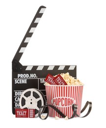 Photo of Tasty popcorn, film reel, clapper and movie tickets isolated on white