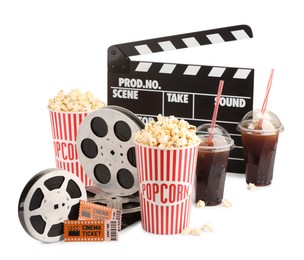 Photo of Tasty popcorn, film reels, clapper, soda drinks and movie tickets isolated on white