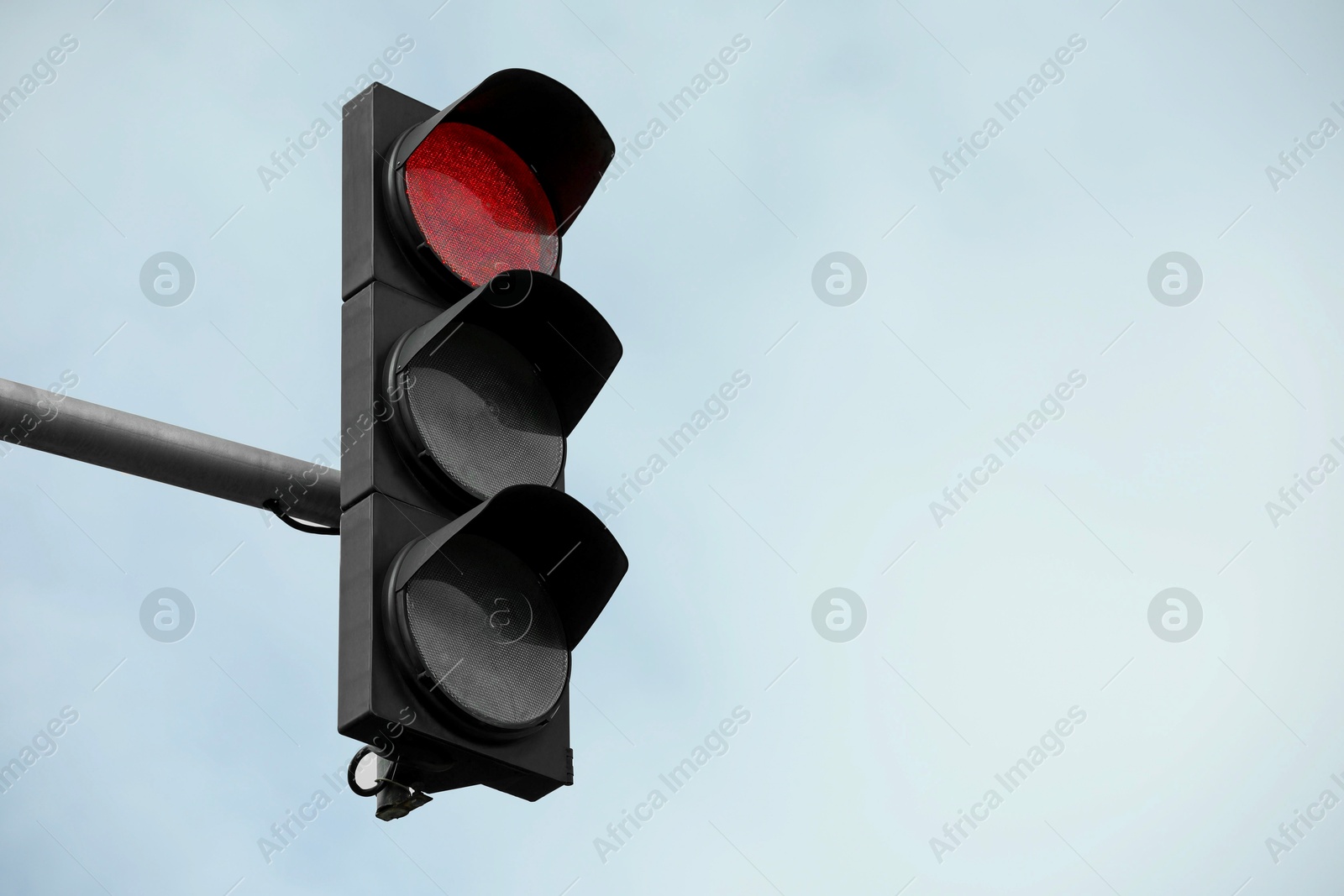 Photo of Traffic light against blue sky in city. Space for text