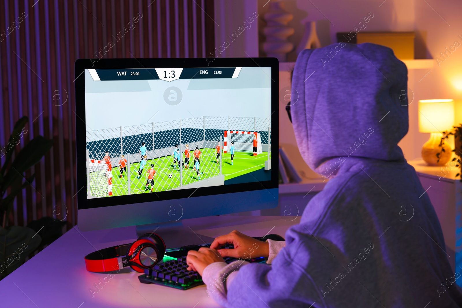 Photo of Woman playing video game with keyboard at table indoors