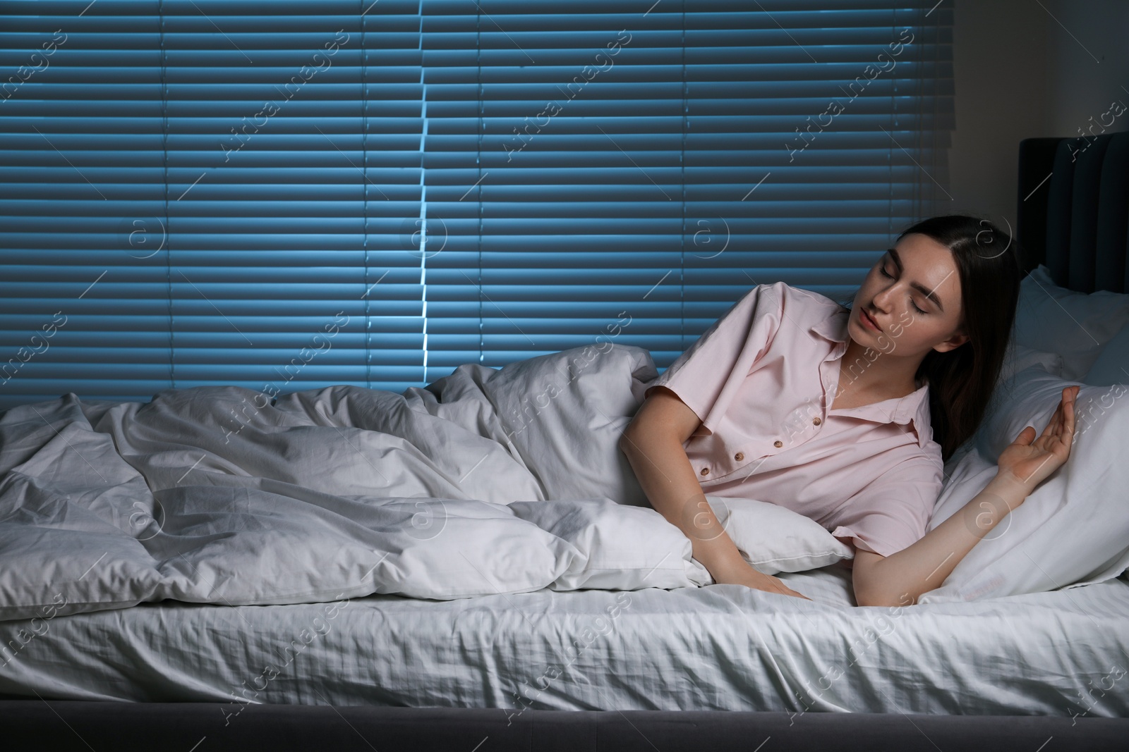 Photo of Young woman suffering from sleepwalking on bed at home