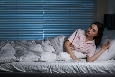 Photo of Young woman suffering from sleepwalking on bed at home