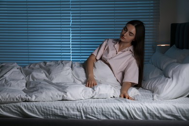 Photo of Young woman suffering from sleepwalking on bed at home