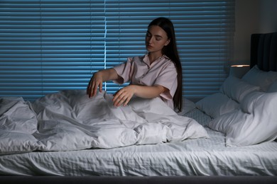 Photo of Young woman suffering from sleepwalking on bed at home