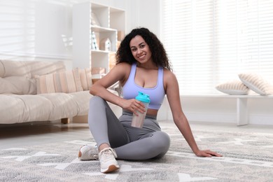 Beautiful woman with protein shake at home