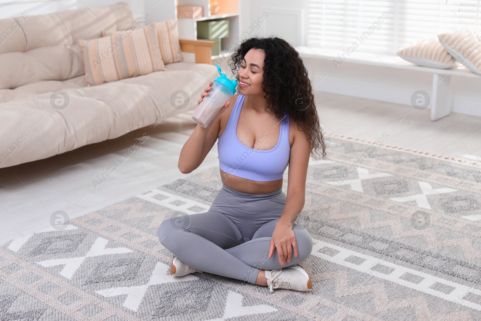 Photo of Beautiful woman drinking protein shake at home