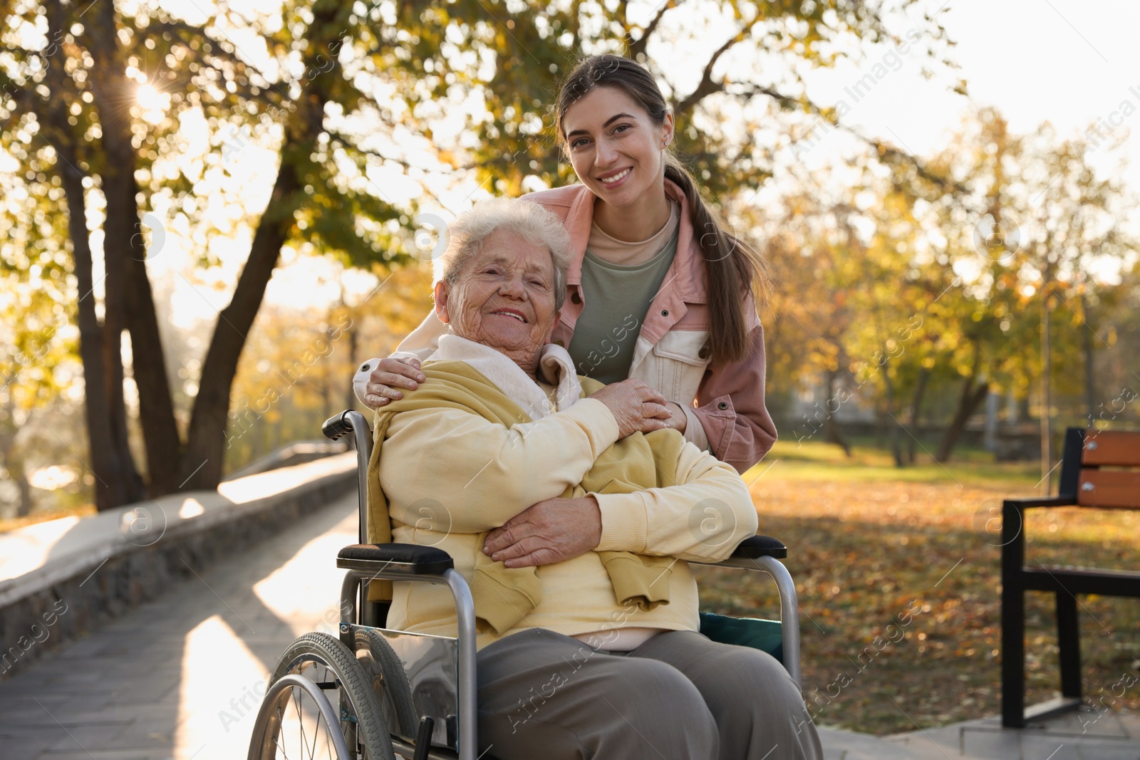 Photo of Caregiver with elderly woman in wheelchair at park