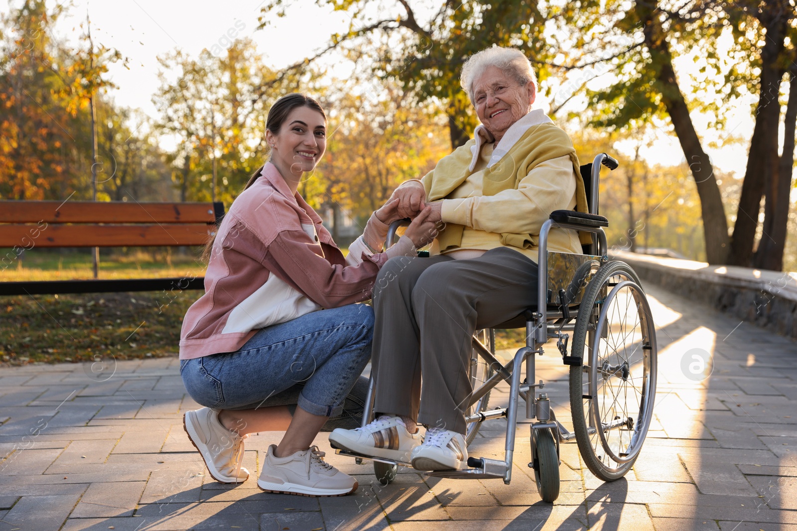 Photo of Caregiver with elderly woman in wheelchair at park