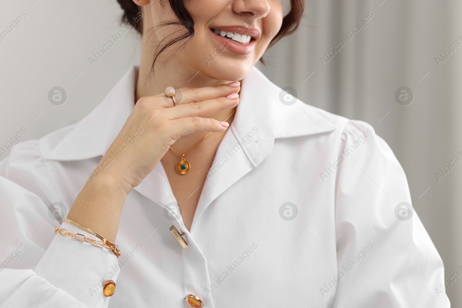 Photo of Young woman wearing elegant jewelry indoors, closeup