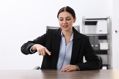 Photo of Beautiful woman pointing at something in office