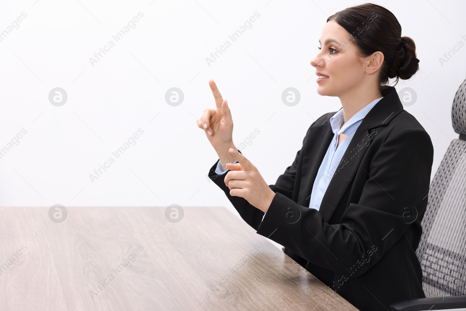 Photo of Beautiful woman pointing at something in office, space for text