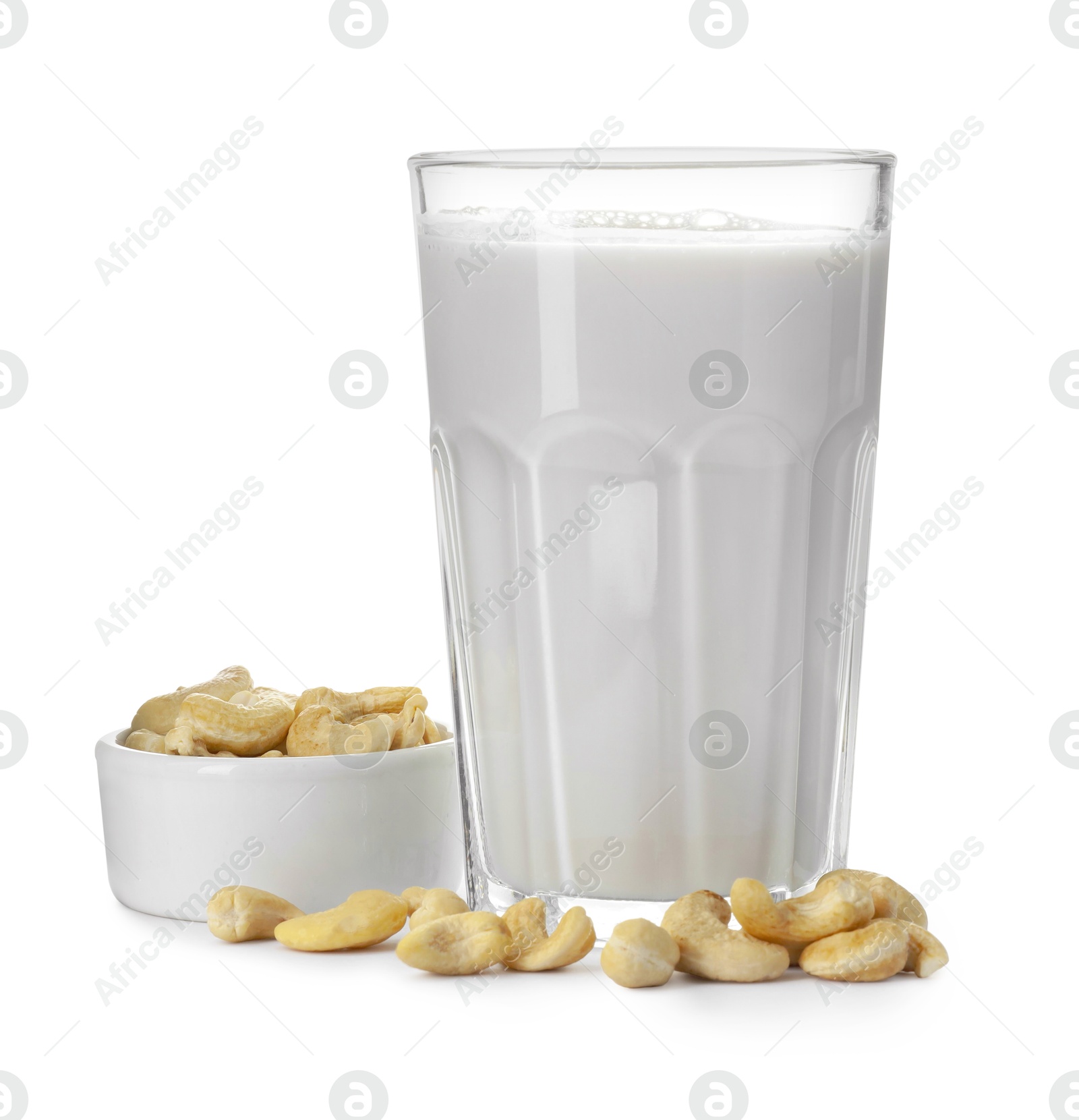 Photo of Fresh cashew milk in glass and nuts isolated on white