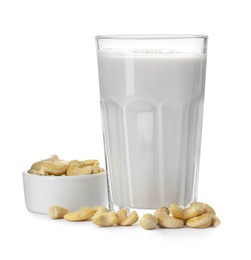 Photo of Fresh cashew milk in glass and nuts isolated on white