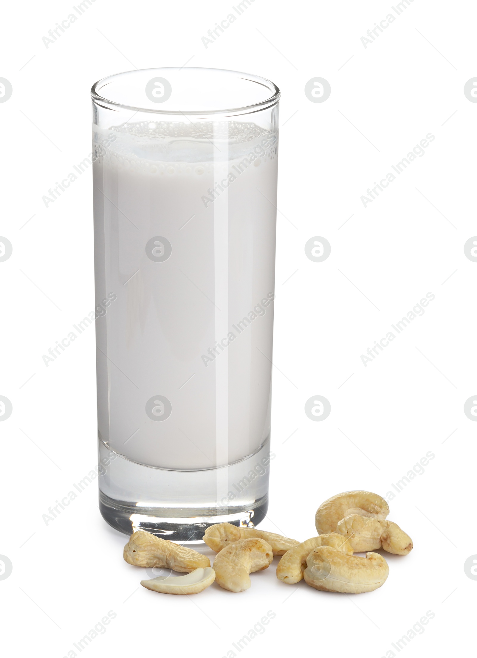 Photo of Fresh cashew milk in glass and nuts isolated on white