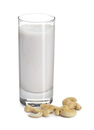 Photo of Fresh cashew milk in glass and nuts isolated on white