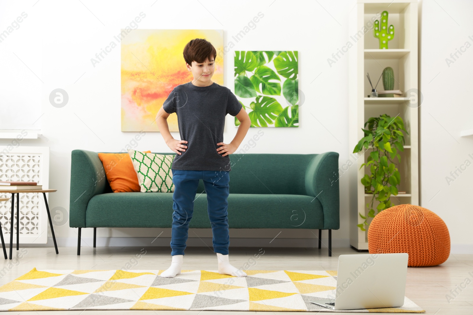 Photo of Boy having training with online coach via laptop at home