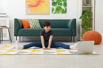 Photo of Boy having training with online coach via laptop at home