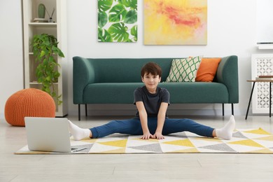 Photo of Boy having training with online coach via laptop at home