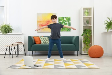 Photo of Boy having training with online coach via laptop at home