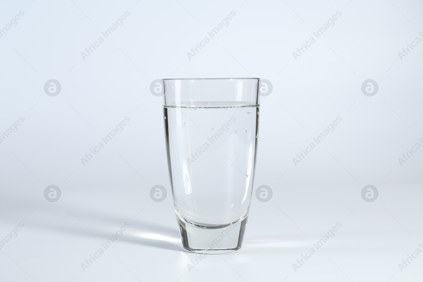 Photo of Refreshing soda water in glass on white background