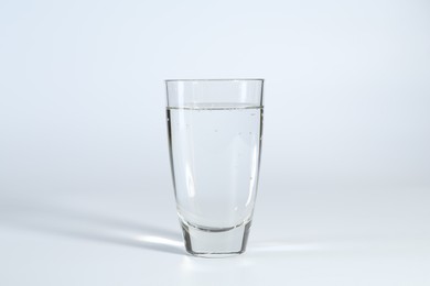 Photo of Refreshing soda water in glass on white background