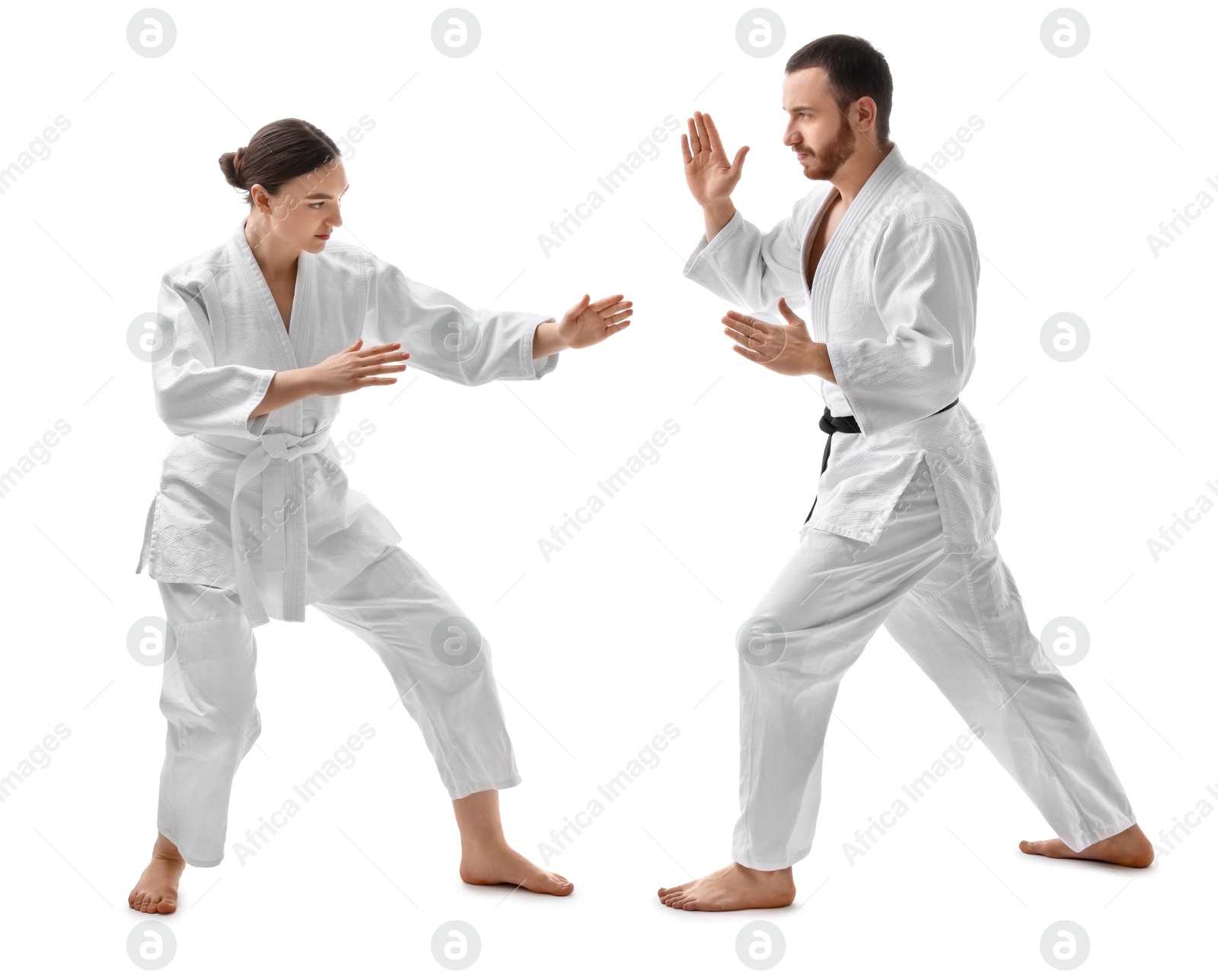 Photo of Man and woman in uniform practicing karate on white background