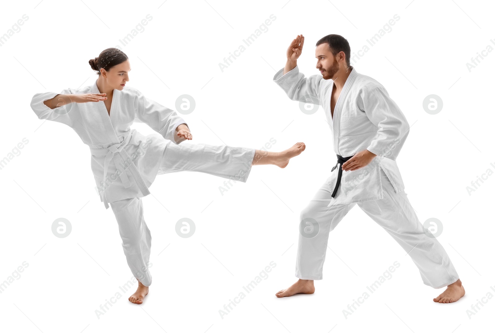 Photo of Man and woman in uniform practicing karate on white background